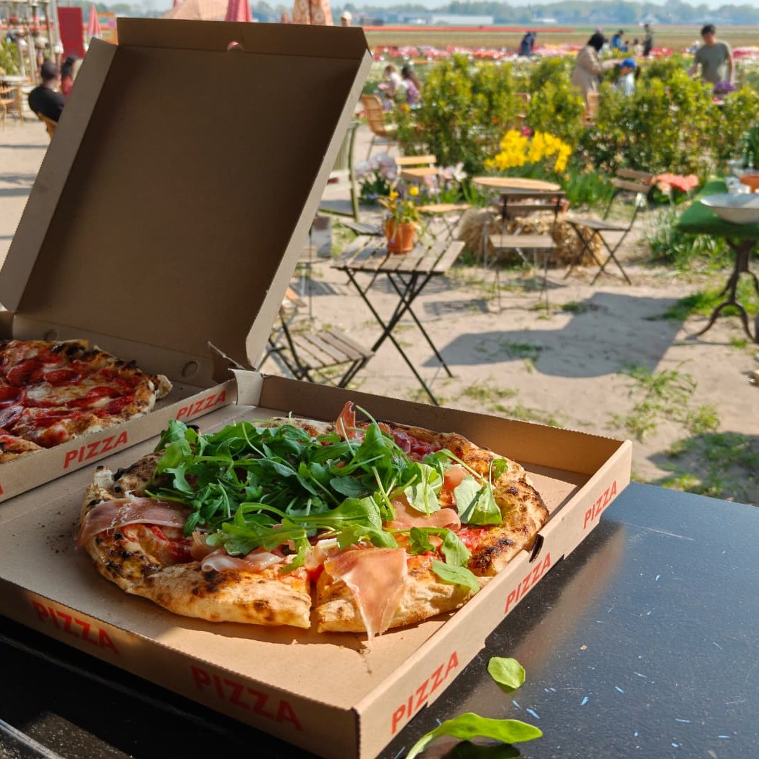 Verse pizza's in dozen op een zonnig evenement